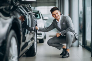 young handsome business man choosing a car in a car showroom